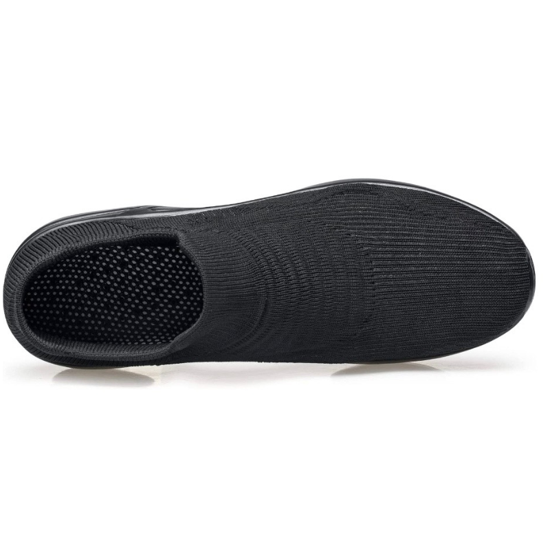 Black slip-on shoe with textured sole on a white background