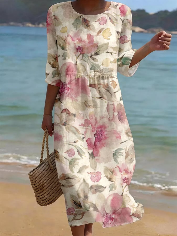 Woman wearing a floral dress on a beach with ocean in the background