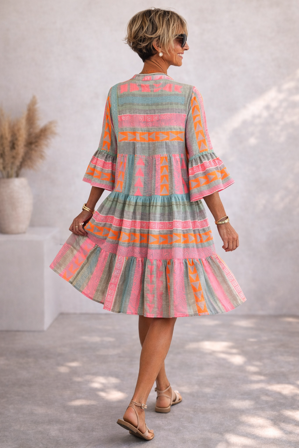 Woman wearing a colorful striped dress in an indoor setting