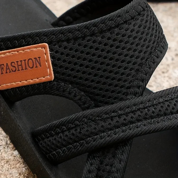 Black pet carrier with mesh design and 'FASHION' label on a textured surface