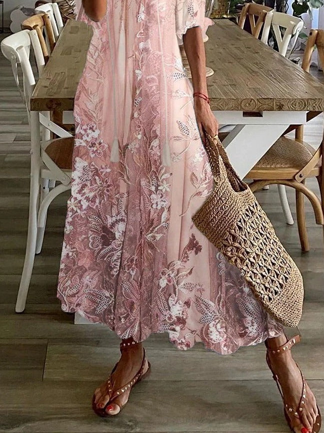 Person wearing a pink floral dress holding a woven bag in a dining area.