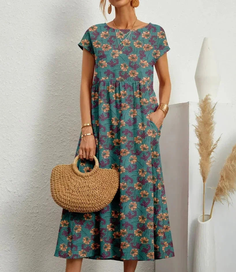 Woman wearing a floral dress holding a woven bag against a white background