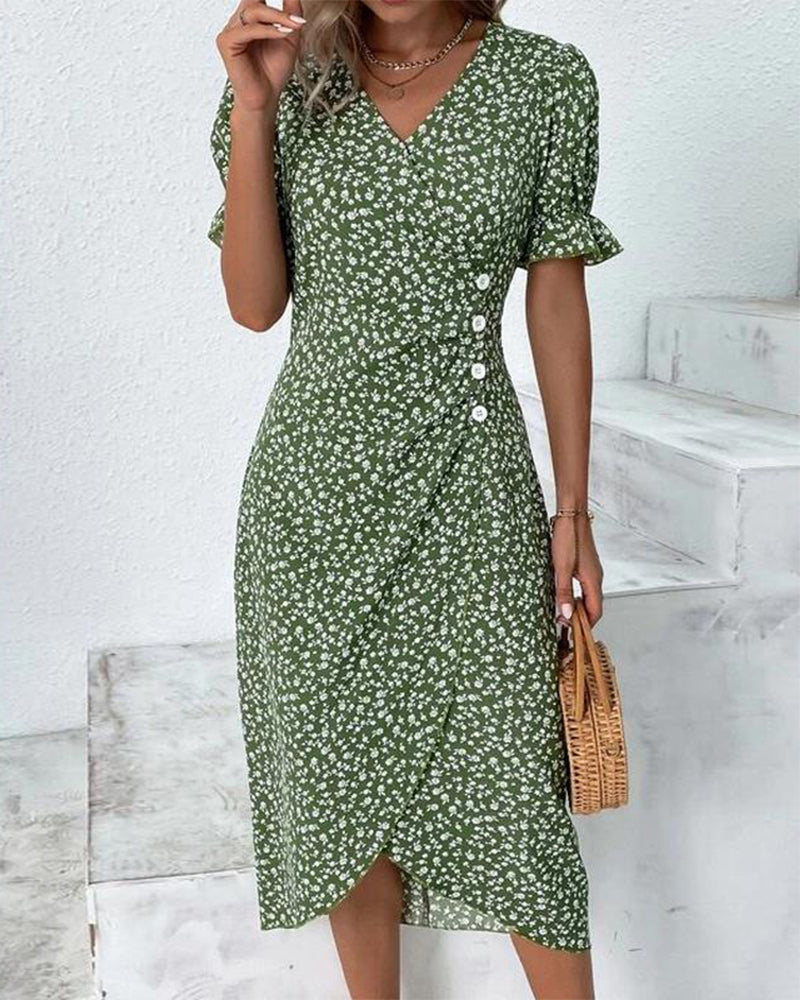 Woman wearing a green floral dress standing on a white staircase.