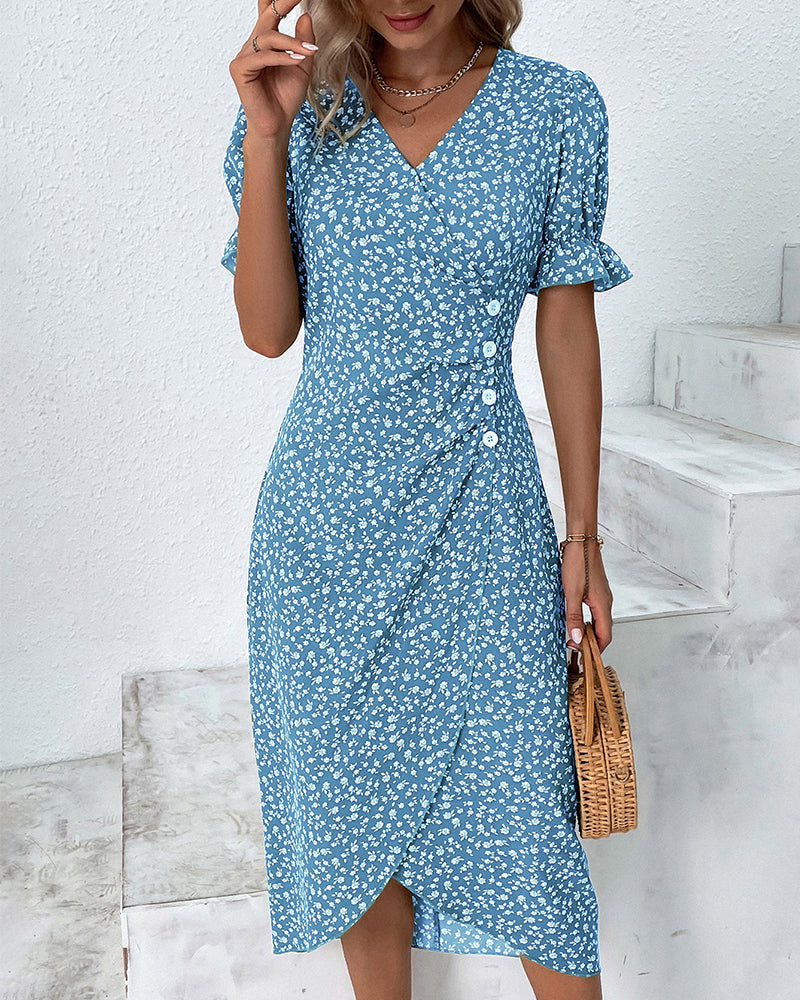 Woman wearing a blue floral dress holding a woven bag indoors.