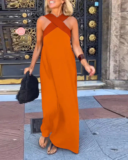 Woman wearing an orange dress with a black bag in front of a decorative door.