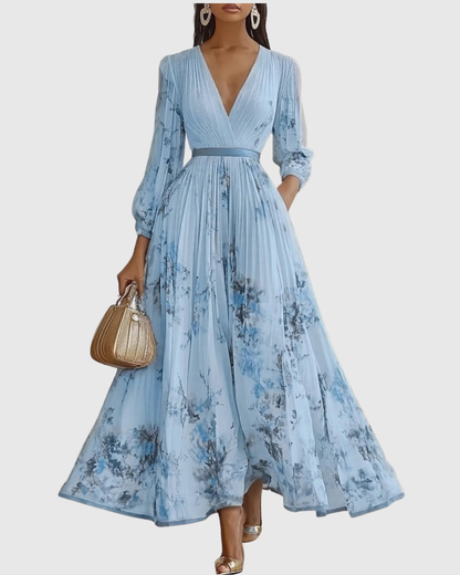 Woman wearing a light blue floral dress with long sleeves on a white background