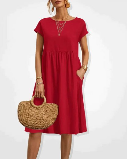 Woman wearing a red dress holding a straw bag on a white background