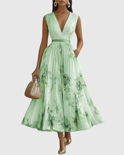 Woman wearing a green floral dress holding a handbag on a white background