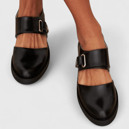 Black shoes with buckle details on a white background