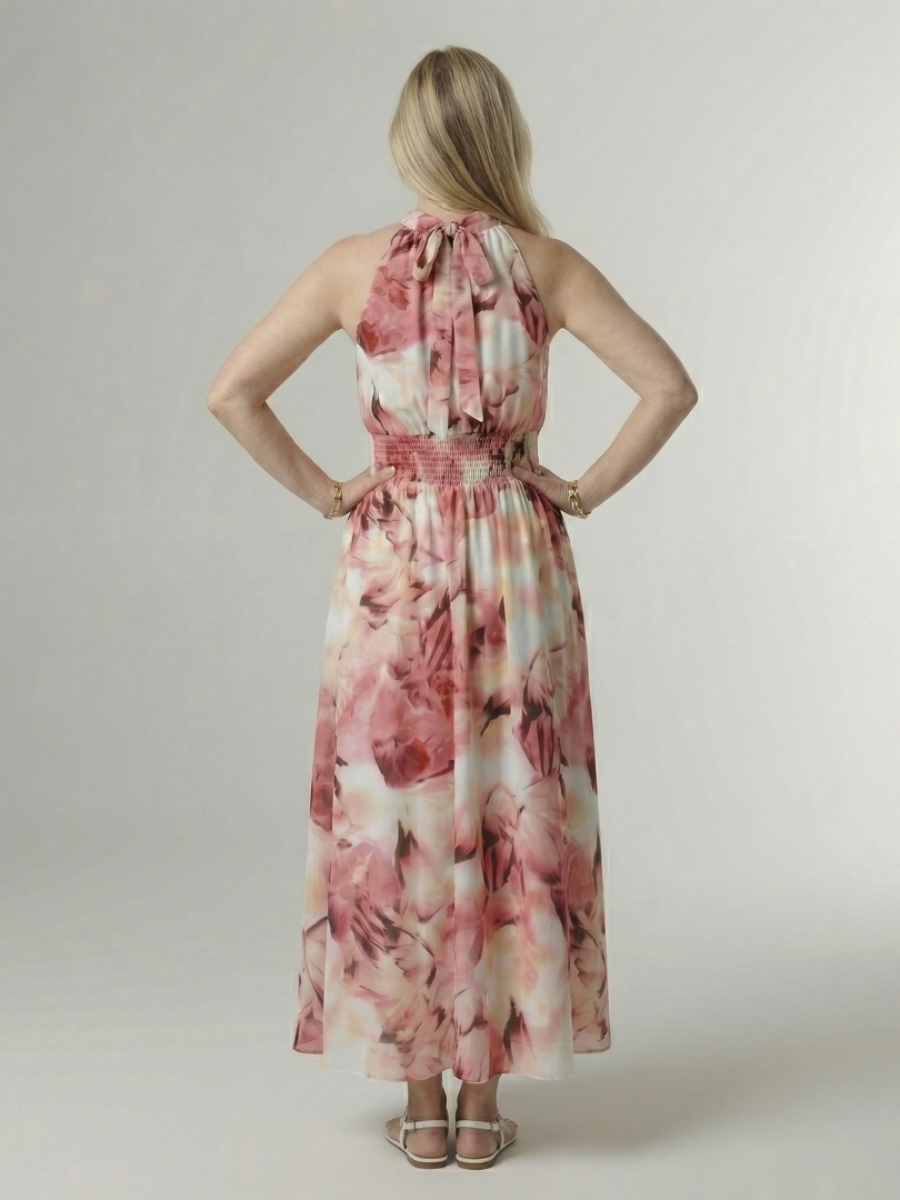 Woman wearing a floral dress against a plain background