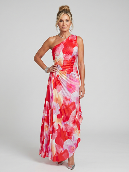 Woman wearing a one-shoulder floral dress on a plain background