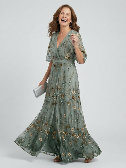 Woman wearing a green floral dress on a white background