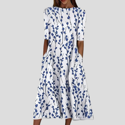 White dress with blue floral pattern on a gray background
