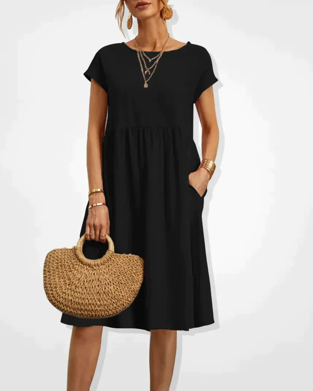 Woman wearing a black dress holding a woven handbag on a white background