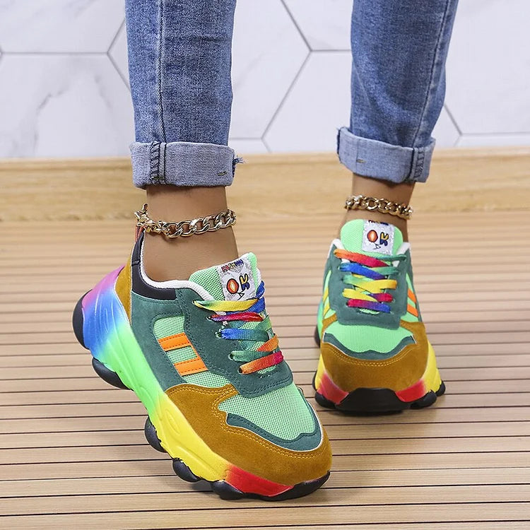 Colorful sneakers with rainbow accents worn on a wooden floor.