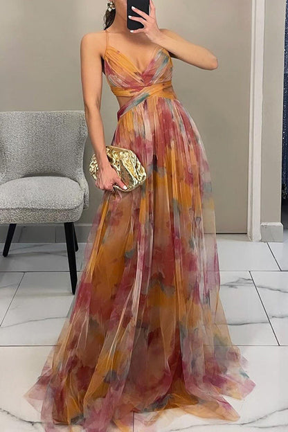 Woman wearing a colorful one-shoulder dress holding a gold clutch in an indoor setting.