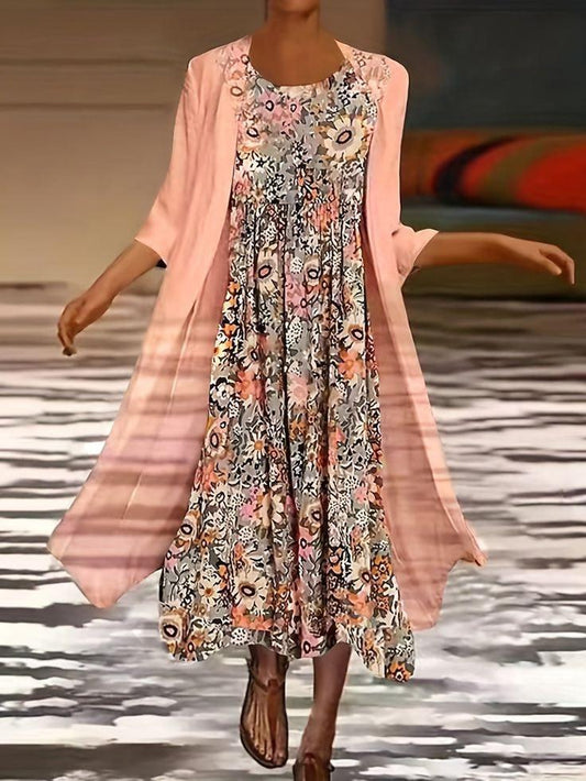 Woman wearing a floral dress with a pink cardigan on a patterned floor.