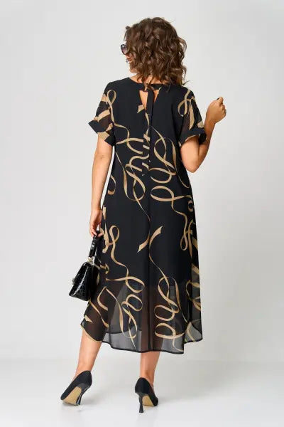 Woman wearing a black dress with gold patterns on a white background
