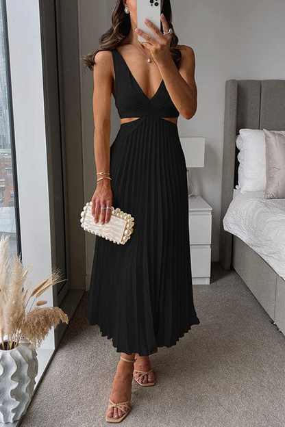 Woman in a black dress taking a mirror selfie in a bedroom.