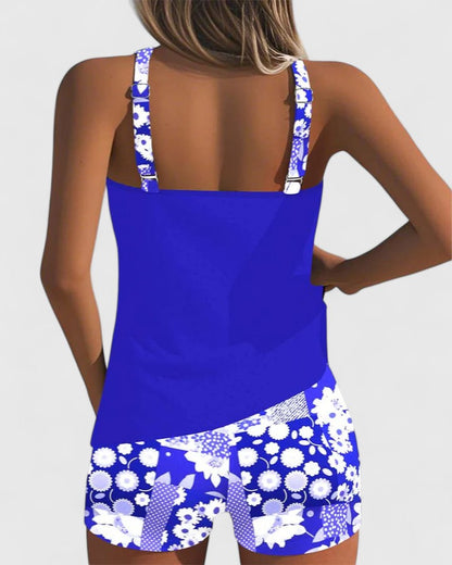 Blue and white floral tankini top and shorts on a plain background