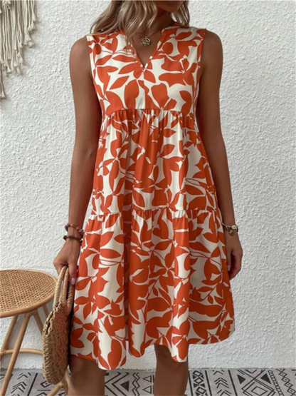 Woman wearing an orange and white patterned dress against a white wall.