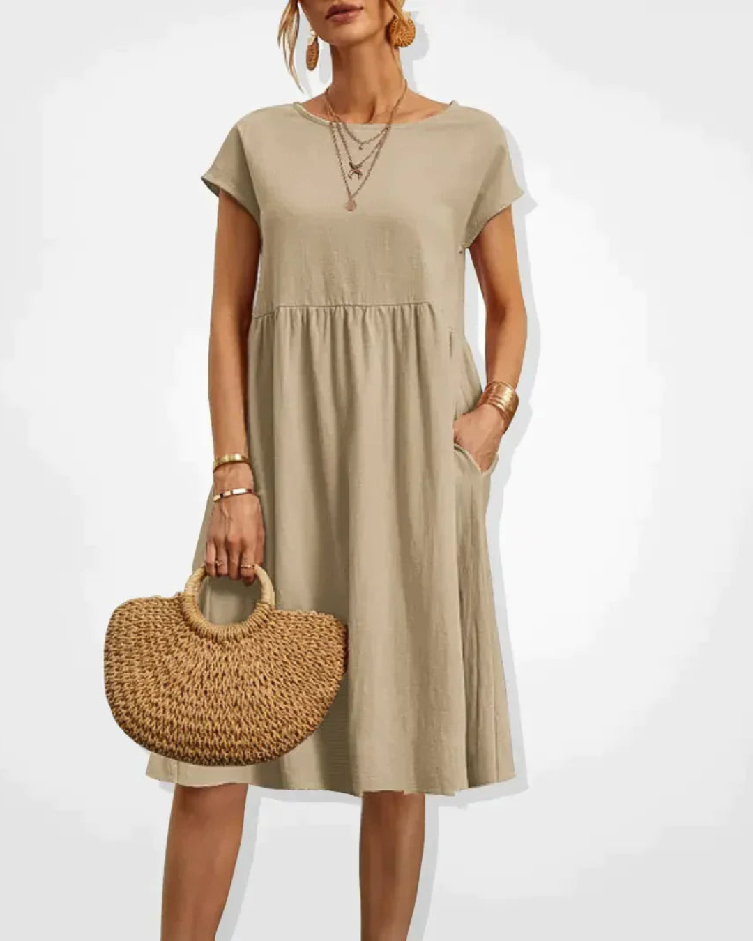 Woman wearing a beige dress holding a woven handbag on a white background