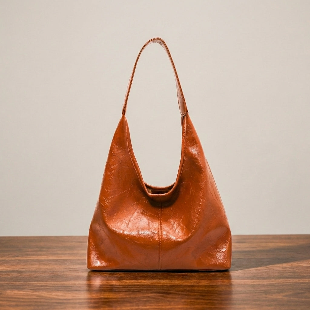 Light brown leather purse on a wooden surface with a beige background