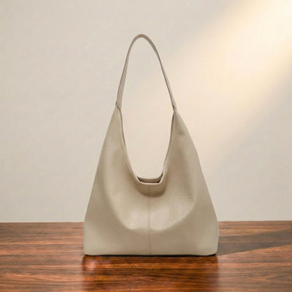 White leather handbag on a wooden surface with a neutral background