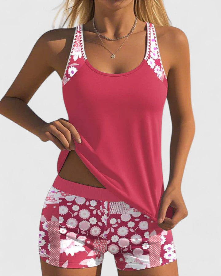 Woman wearing a pink tank top and floral shorts on a white background