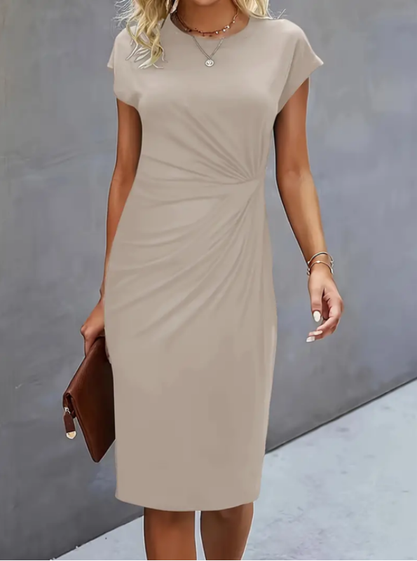 Woman wearing a beige dress against a gray background