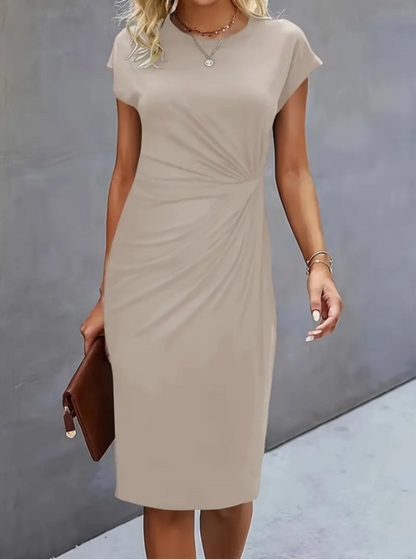 Woman wearing a beige dress against a gray background