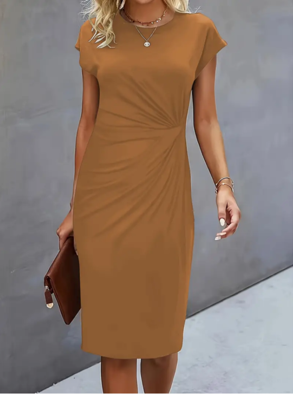 Woman wearing a brown dress against a gray background