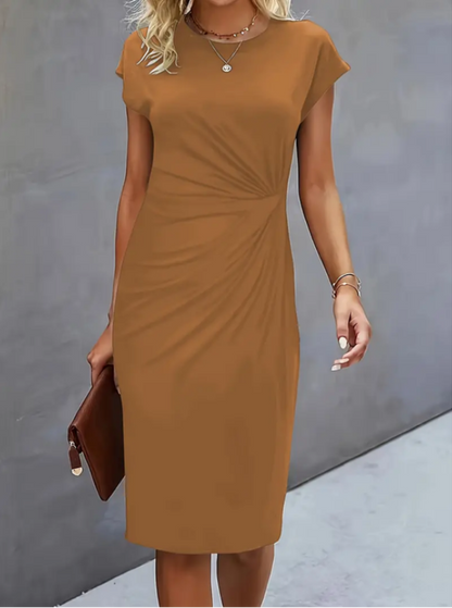 Woman wearing a brown dress against a gray background