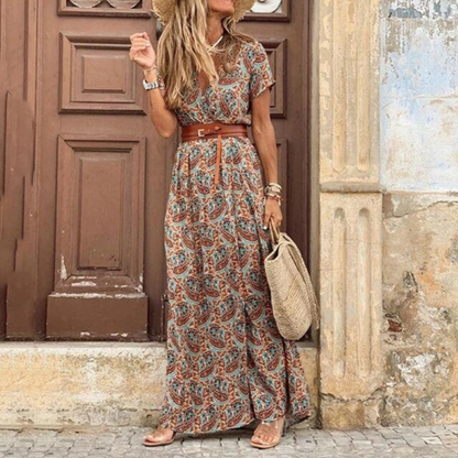 Woman in a patterned dress standing in front of a textured wall.