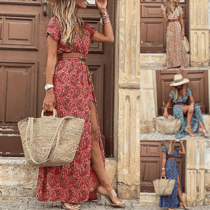 Woman in a red floral dress holding a straw bag, standing in front of a stone building.