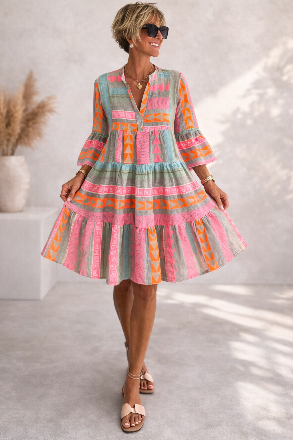 Woman wearing a colorful patterned dress with a neutral background