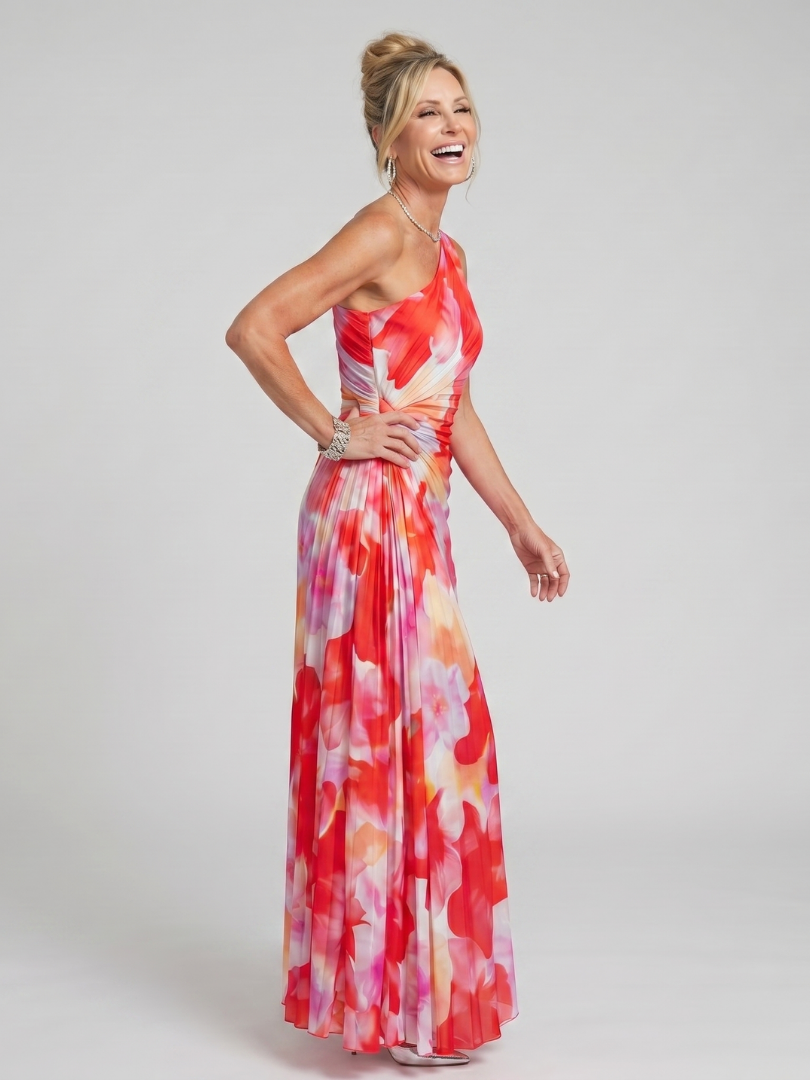 Woman wearing a colorful floral dress on a plain background
