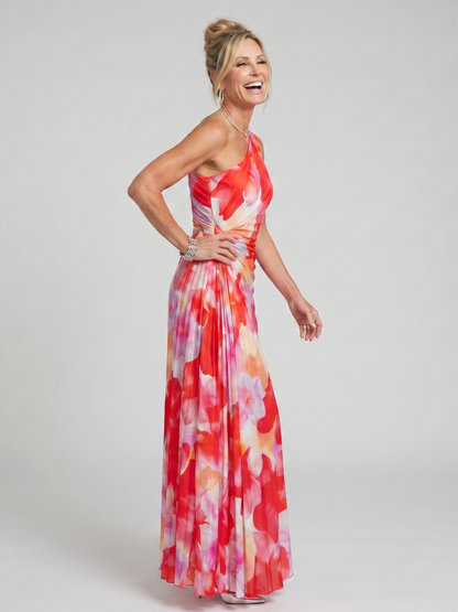 Woman wearing a colorful floral dress on a plain background