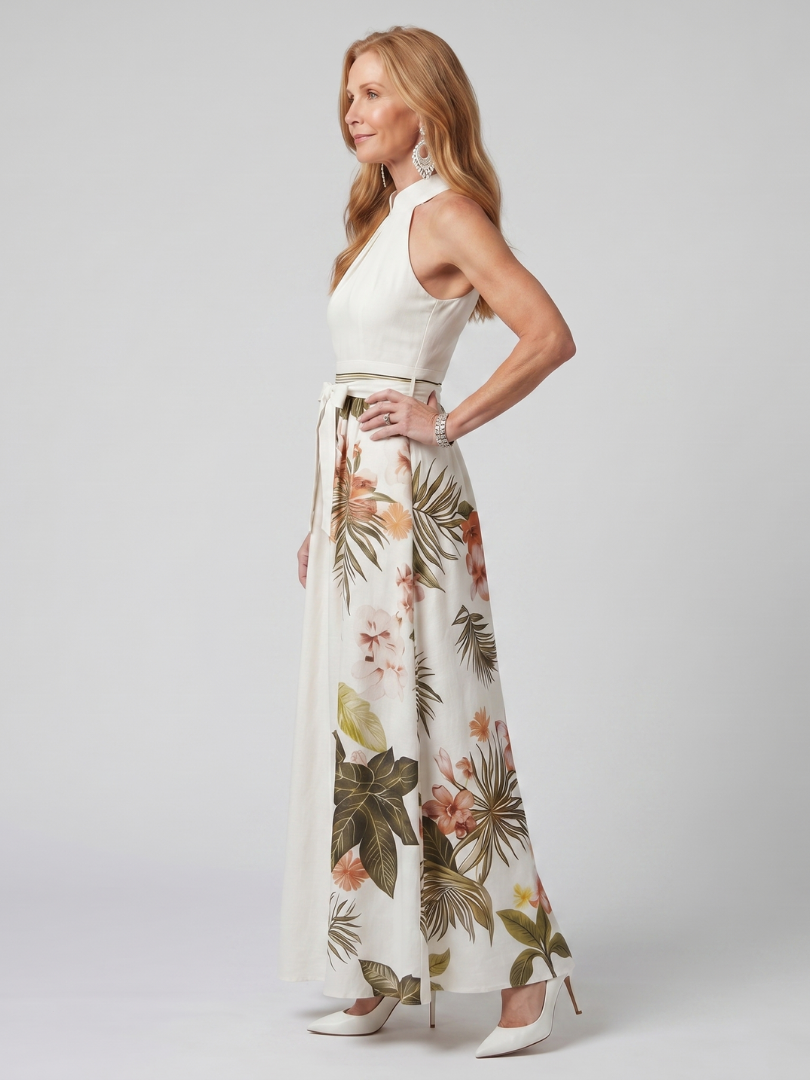 Woman wearing a white sleeveless top and floral maxi skirt on a plain background