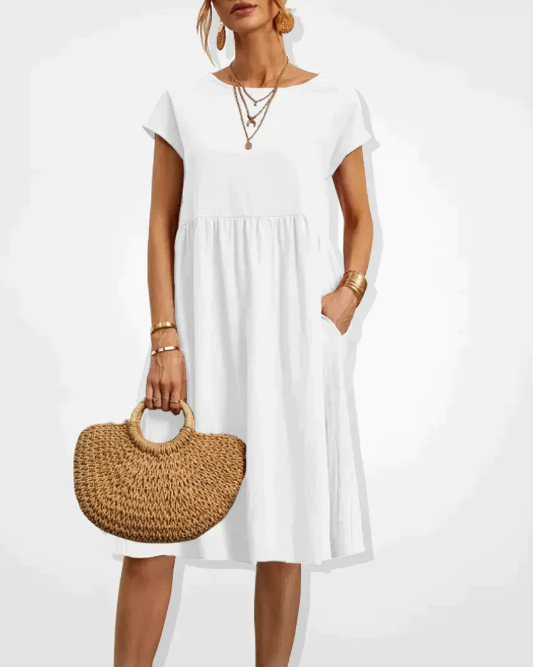 Woman wearing a white dress holding a woven handbag on a white background