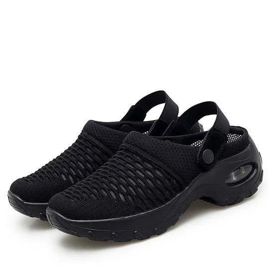 Black slip-on shoes with textured sole on a white background