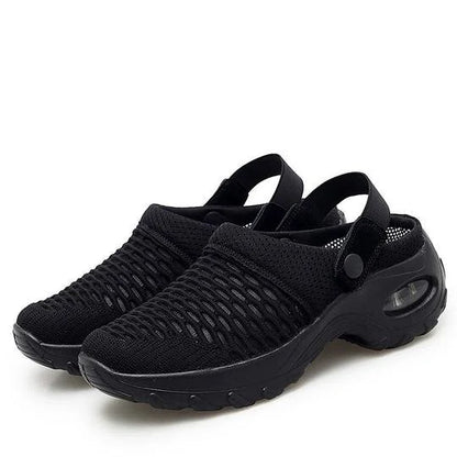 Black slip-on shoes with textured sole on a white background