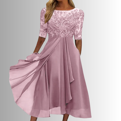 Pink lace dress with flowing fabric on a gray background
