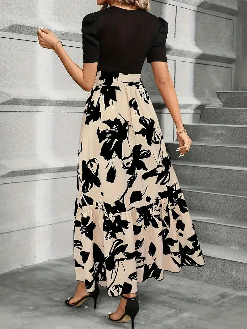 Woman wearing a black and white floral dress on stone steps.