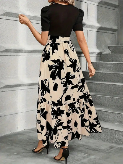 Woman wearing a black and white floral dress on stone steps.