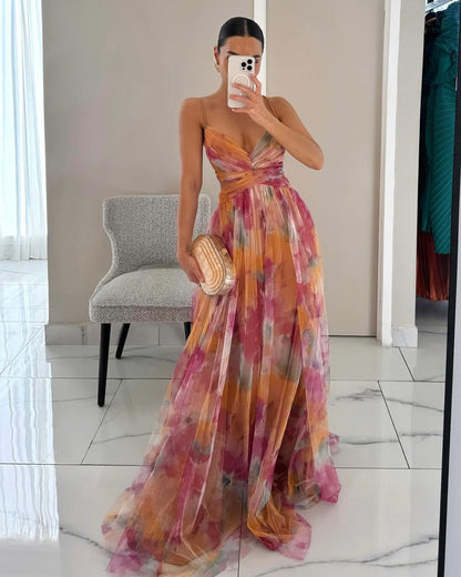Woman in a colorful floral dress taking a mirror selfie in a room.