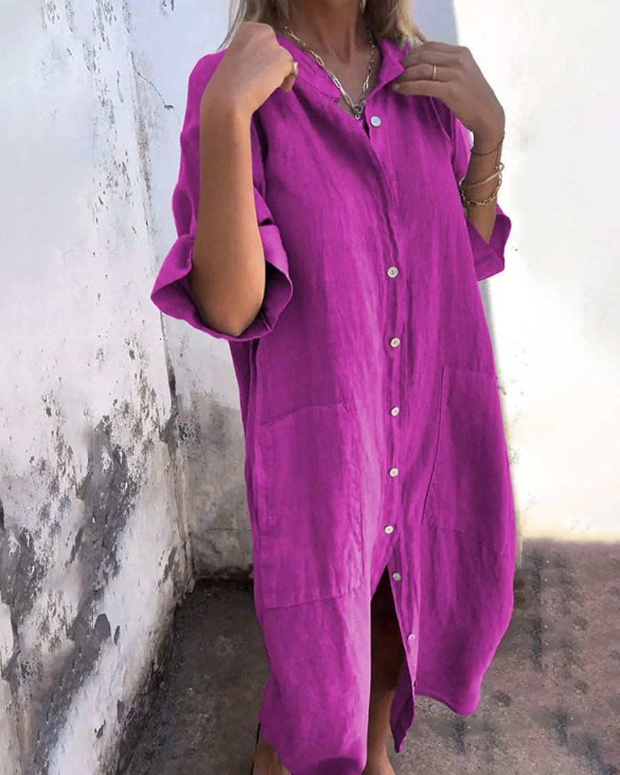 Person wearing a bright pink dress with a textured wall background