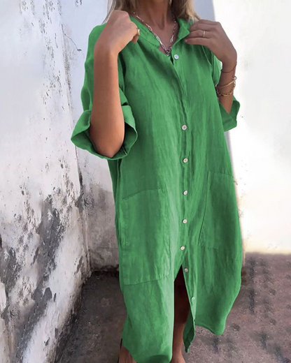 Green dress worn by a person against a white wall.