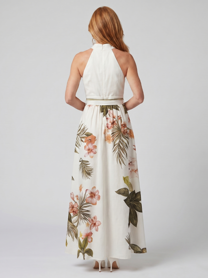 Woman wearing a white halter top and floral skirt on a plain background