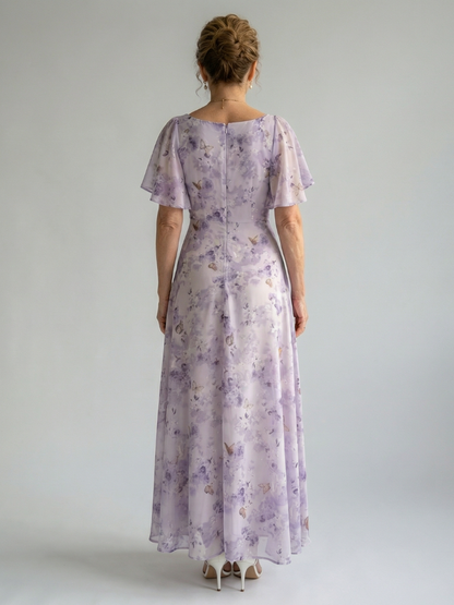 Woman wearing a floral dress with short sleeves on a plain background